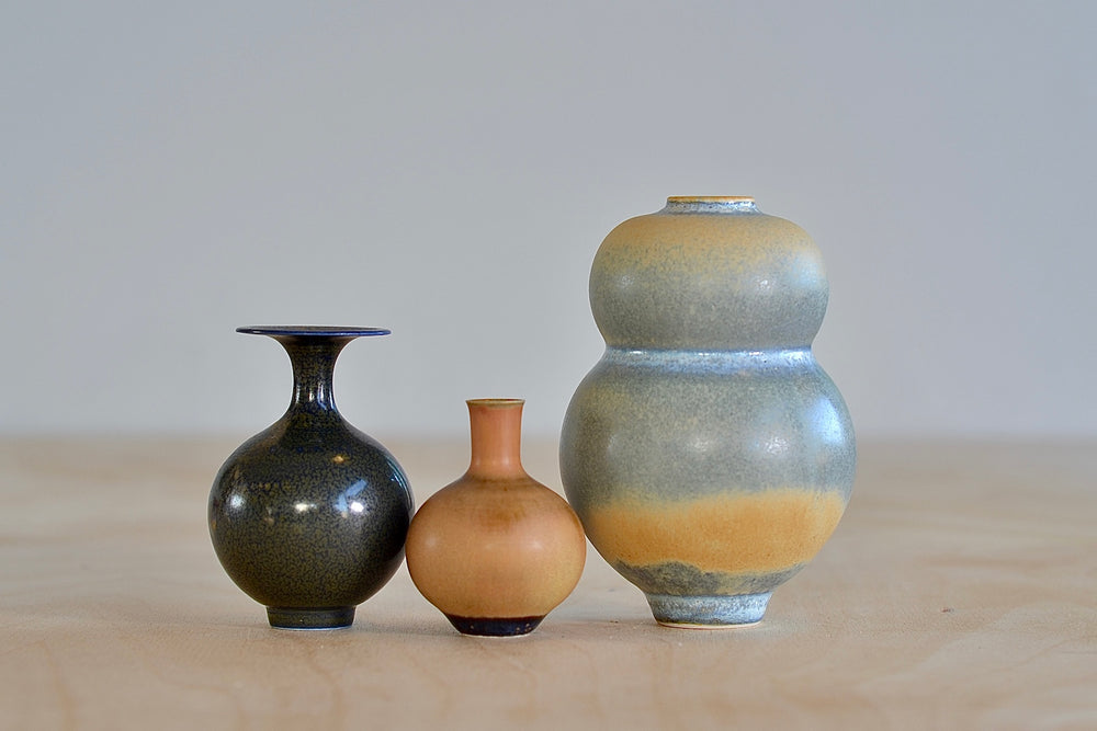 
            
                Load image into Gallery viewer, Miniature Hand Thrown Ceramic Vase Trio in Gray Blue with orange, Ochre and Dark Brown on white background by Yuta Segawa.
            
        