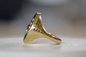 
            
                Load image into Gallery viewer, Side view of Retrouvai Turquoise Compass Signet ring with Diamonds and tanzanite accent stone in 14k yellow gold and inlay.
            
        
