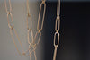 Detail of long and short 14k gold paperclip chains (necklaces) with two short, one long flat clips in 15 or 17 inches by Kaylin Hertel.