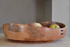 
            
                Load image into Gallery viewer, Apples sticking out of the Circle Factory bowl in Maple by Geoarge Peterson is a blonde wood apple bowl with repairs deatail.
            
        