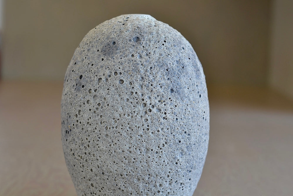 Close up of Heather Rosenman oval ceramic vase in gray to white volcanic glaze.