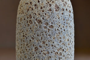 
            
                Load image into Gallery viewer, Detail of Tall Heather Rosenman cream to gray ceramic bottle vase in volcanic glaze.
            
        