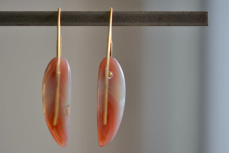 View from the back of feather earrings in red agate by Rachel Atherley.
