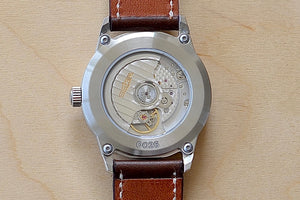
            
                Load image into Gallery viewer, Close up of Back side of Weiss Watch 38mm Automatic Issue Field Watch with Latte Beige Dial and date, shown with dark brown Horween Leather strap. 
            
        