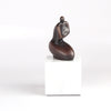Anne Ricketts Berecuse Sculpture of modern woman in brass on white background.