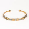 Snake Cuff bravelet by Arman Sarkysian in 18k gold features two coiled snakes  in oxidize d silver with three white diamonds each,l ooking at each other, with a center stoen in the middle on a carved goild cuff that is semi flexible but fits small writst best. 