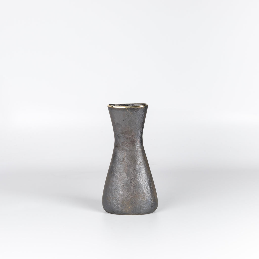 Another angle on Werkstatte Carl Aubock Vase 7231 called Hourglass in patina brass with polished rim on white.