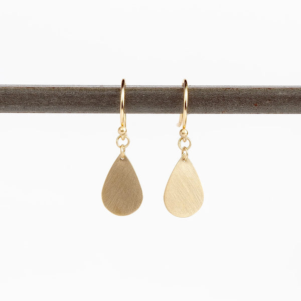 Pair of Teardrop Earrings by Carla Caruso. A single gold and flat teardrop hangs from an ear wire in 14k satin gold, allowing for lots of movement. Handmade in Massachusetts.