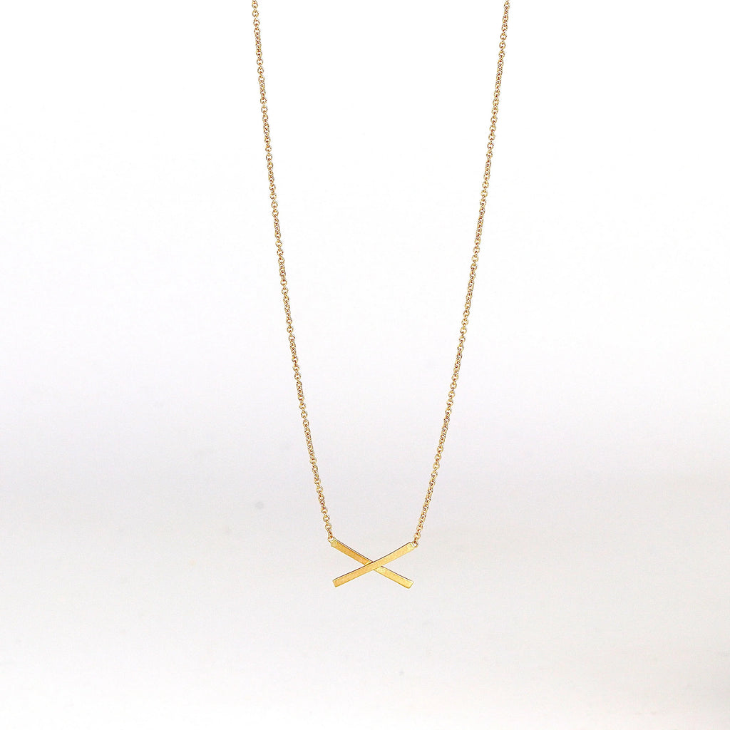 Mini X necklace on white background by Carla Caruso.