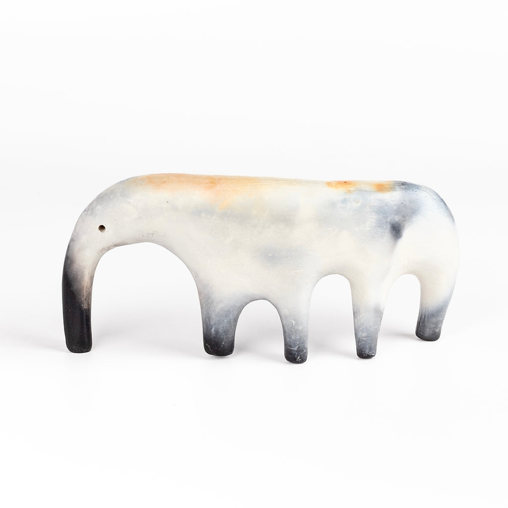 An ambigous ceramic creature  figurine formed from solid clay and refined by hand, this "one of a kind" ceramic creature is made out of white earthenware and white terra sigillata before getting pit fired in the wilderness. Made by Carol Horst in Los Angeles.