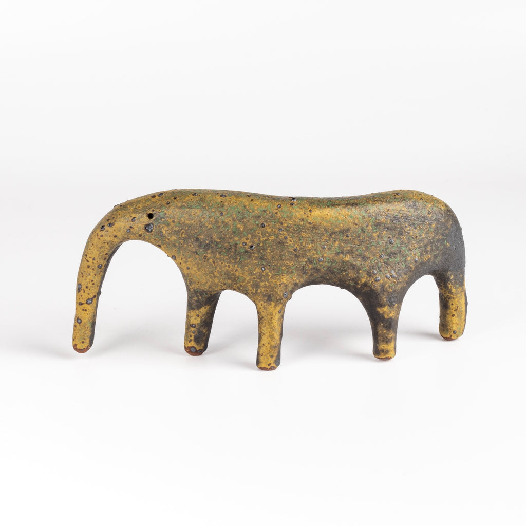 A yellow ceramic creature is ofrmed from solid clay and refined by hand, this "one of a kind" ceramic creature is made out of stoneware and glazed before getting reduction fired. Made by Carol Horst in Los Angeles.