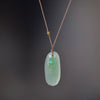 Chrysoprase and Sapphire Pendant Necklace by Margaret Solow is an organic necklace consisting of a smaller and bezel set green sapphire on top of a larger oval pale green raw chrysoprase that hangs on a cord with an 18k gold bead and has a clasp closure.
