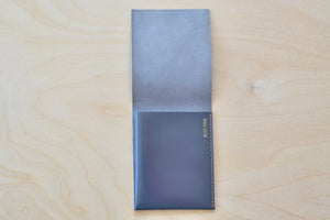 Inside of Soft Gray Alice Park simple flap wallet with orange-peach stitching.