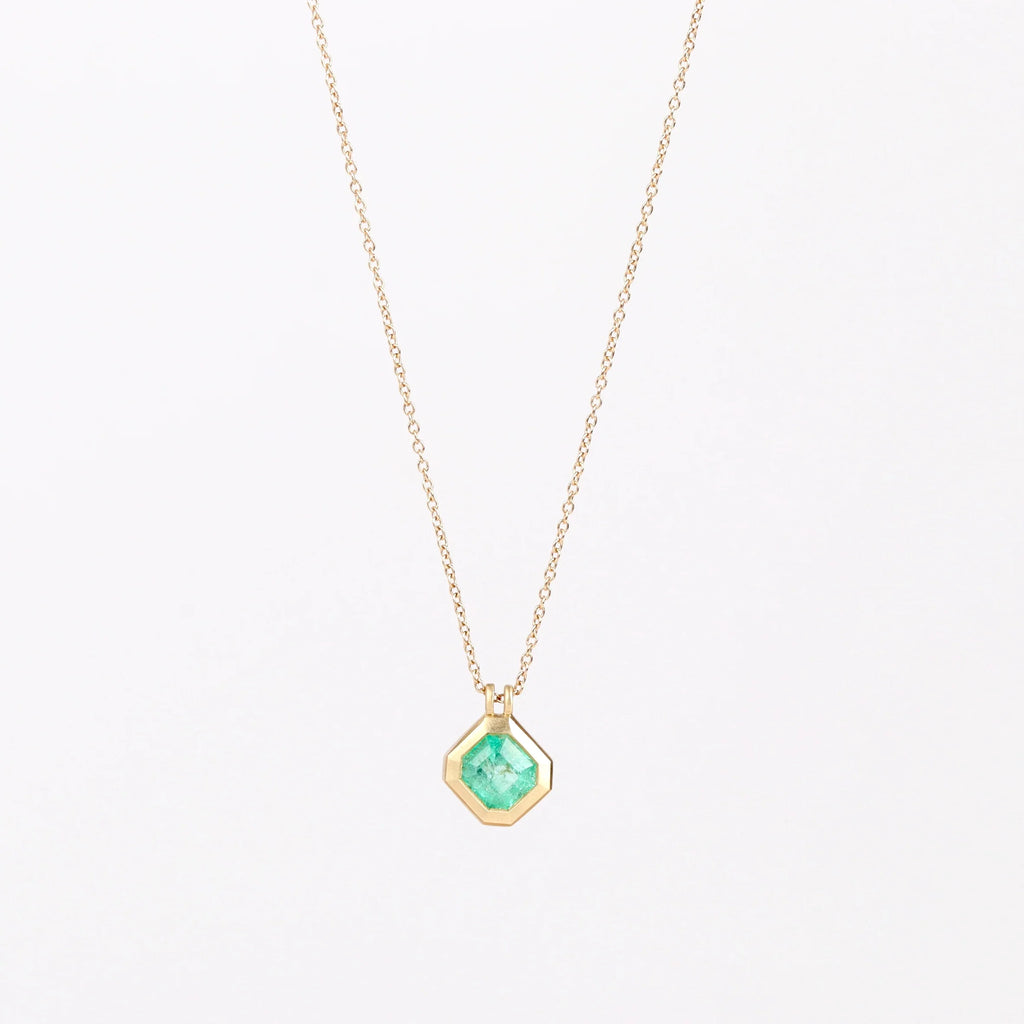 Duo Bale Offset Emerald Necklace by Elizabeth Street Jewelry is a  bezel set, translucent and offset square Colombian emerald with twin bales and on a 14k yellow gold chain. Perfect for layering or to wear as a solo piece. 