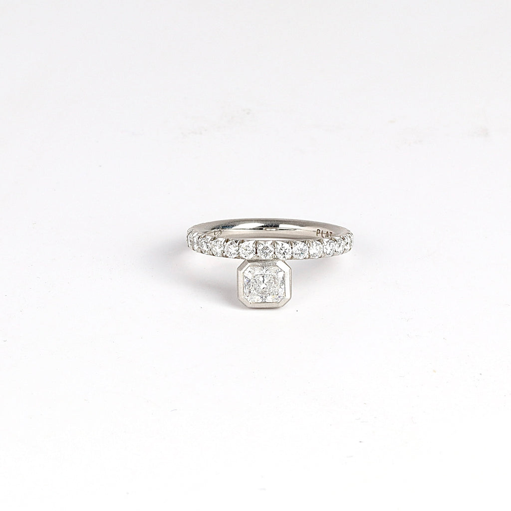 Offset Floating Solitaire by Elizabeth Street Jewelry is an offset center radiant cut white diamond (IVS1) .76ct on a 3/4 eternity band of white diamonds in platinum.