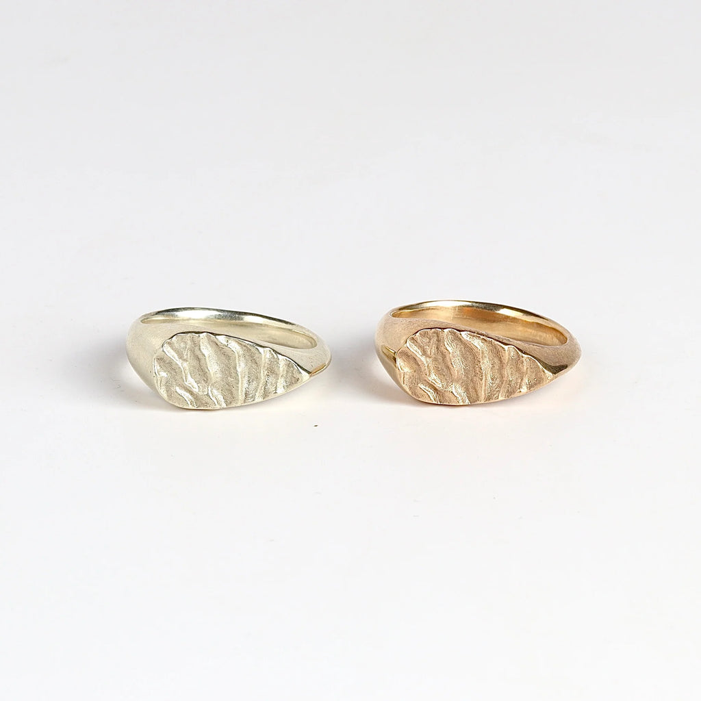 Tidal Teardrop Signet rings in white and yellow gold also known as The 'Tidal 12' is a teardrop shaped and solid modern signet ring in 9k yellow or white gold with polished band and matte face, featuring the maker's signature 'low tide' or 'ripple' texture on the face.