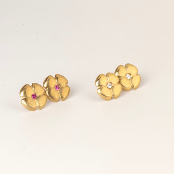 Large flower stud earrings by Kaylin Hertel  on white background shown in white diamond and magenta pink sapphire in 14k gold .