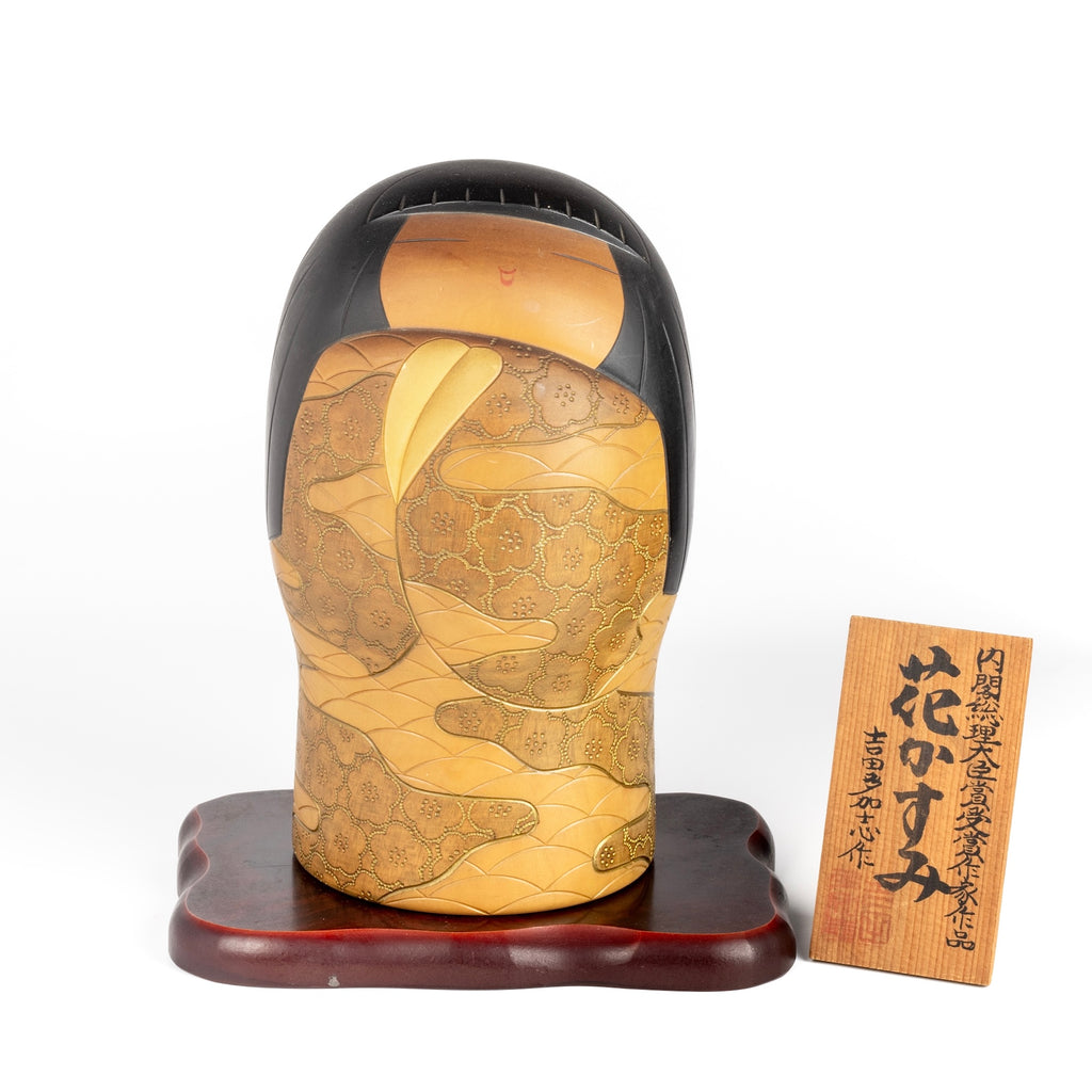 Vintage "Hana Kasumi" is a beautiful Sosaku Kokeshi by master Yoshida Takashi (1948- 2007). He has won many awards including the Prime Minister's Award and is known for rare and exclusive pieces. This one is of a girl, wrapped in a kimono that is hand carved with intricate patterns and painted in vibrant colors. It is quite big and heavy. Stamped and includes a stand and plaque. In good vintage condition. Handmade in Japan.