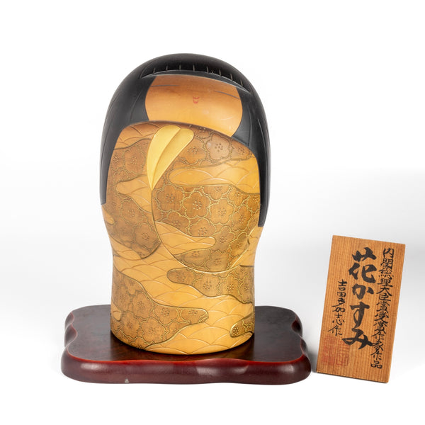 Vintage "Hana Kasumi" is a beautiful Sosaku Kokeshi by master Yoshida Takashi (1948- 2007). He has won many awards including the Prime Minister's Award and is known for rare and exclusive pieces. This one is of a girl, wrapped in a kimono that is hand carved with intricate patterns and painted in vibrant colors. It is quite big and heavy. Stamped and includes a stand and plaque. In good vintage condition. Handmade in Japan.