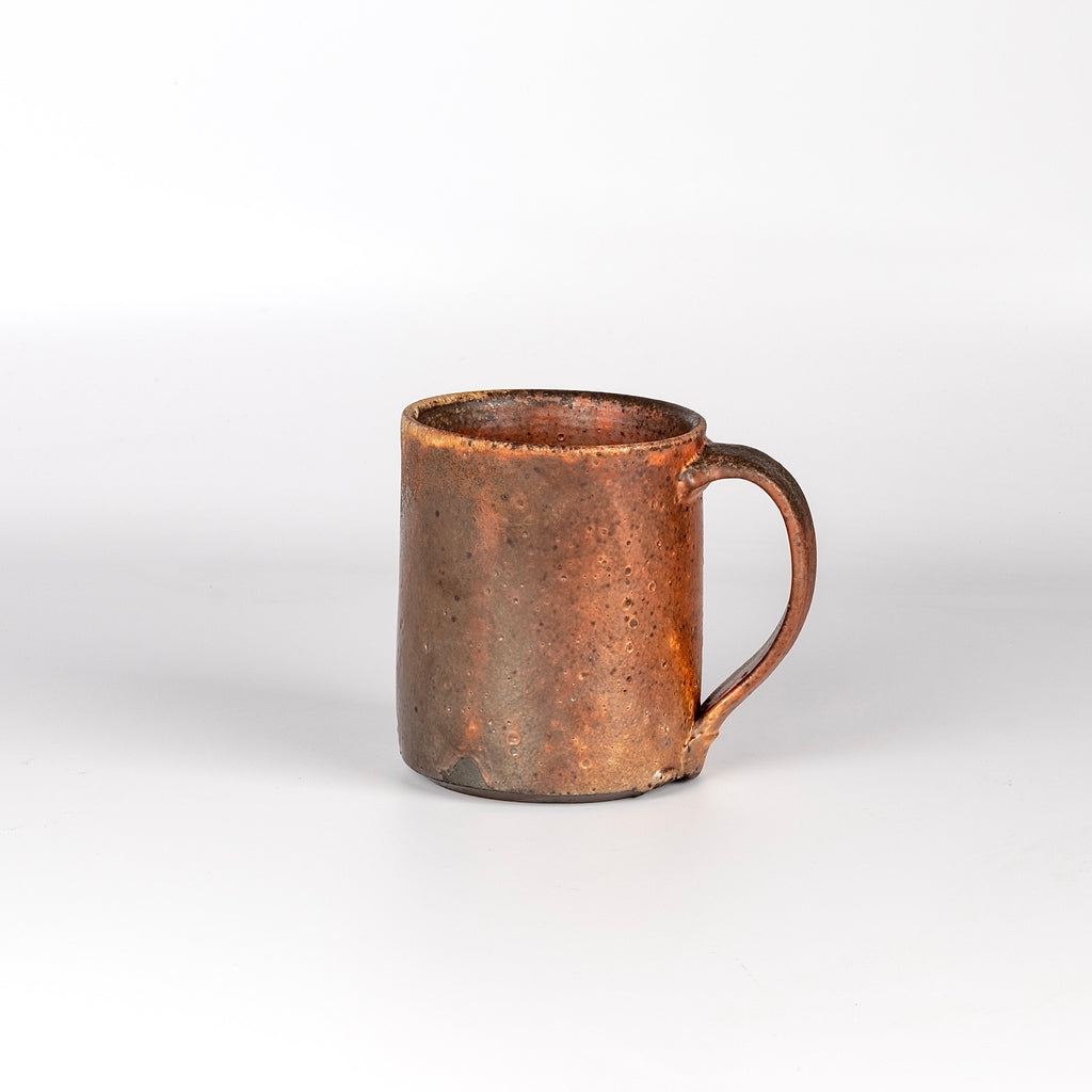 The LO mug is a wood fired ceramic mug by Lindsey Oesterritter. Wood ash in the kiln results in highly varying surfaces so each one unique and one of a kind. This one is number 2.