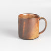 A wood fired  ceramic mug by master of wood fired ceramics, Lindsay Oesterritter. Wood ash in the kiln results in highly varying surfaces so each mug is unique,. As beautiful as they are functional. Sizes vary slightly, glazes considerably. One of a kind.