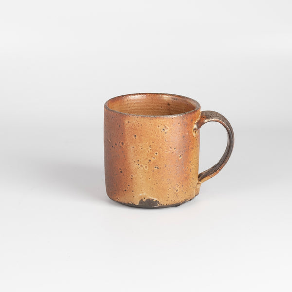 A wood fired  ceramic mug by master of wood fired ceramics, Lindsay Oesterritter. Wood ash in the kiln results in highly varying surfaces so each mug is unique,. As beautiful as they are functional. Sizes vary slightly, glazes considerably. One of a kind.