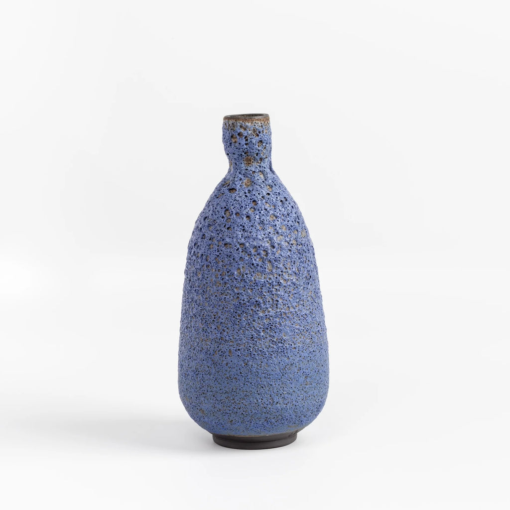 Tall Blue Bottle vase in volcanic glaze by Heather Rosenman on white background.