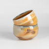 Two hand thrown and wood fired porcelain bowls by Lilith Rockett.