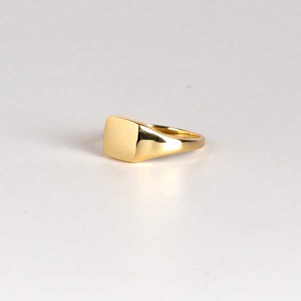 Side view of Rectangle Reflection Signet by Makiko Wakita, an 18k high polish signet ring with crisp edges and a horizontally oriented slightly rectangularl face. This signet ring is unisex. Size 6. Handmade in Los Angeles.