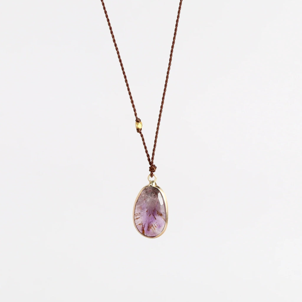 Super 7 Pendant Necklace designed by Margaret Solow is a An Individual faceted, translucent and purple Super 7 crystal slice with natural inclusions set in 14k gold with with a gold bead on the string makes this one of a kind organic pendant necklace.