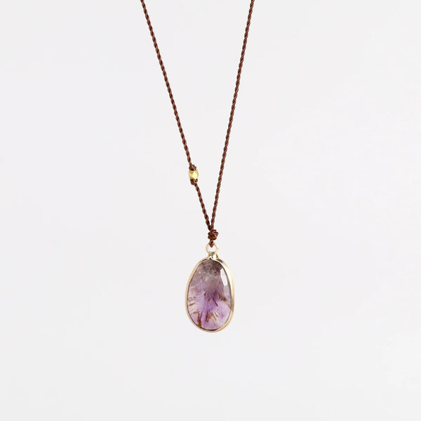 Super 7 Pendant Necklace designed by Margaret Solow is a An Individual faceted, translucent and purple Super 7 crystal slice with natural inclusions set in 14k gold with with a gold bead on the string makes this one of a kind organic pendant necklace.