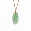 Close up of Chrysoprase and Sapphire necklace, a one of a kind lightly faceted Chrysoprase stone slice accompanied by a smaller green and faceted sapphire slice of which the smaller is set in 18k gold with with a gold bead on the string makes this one of a kind &nbsp;organic pendant necklace. Designed by Margaret Solow. Handcrafted in Los Angeles.