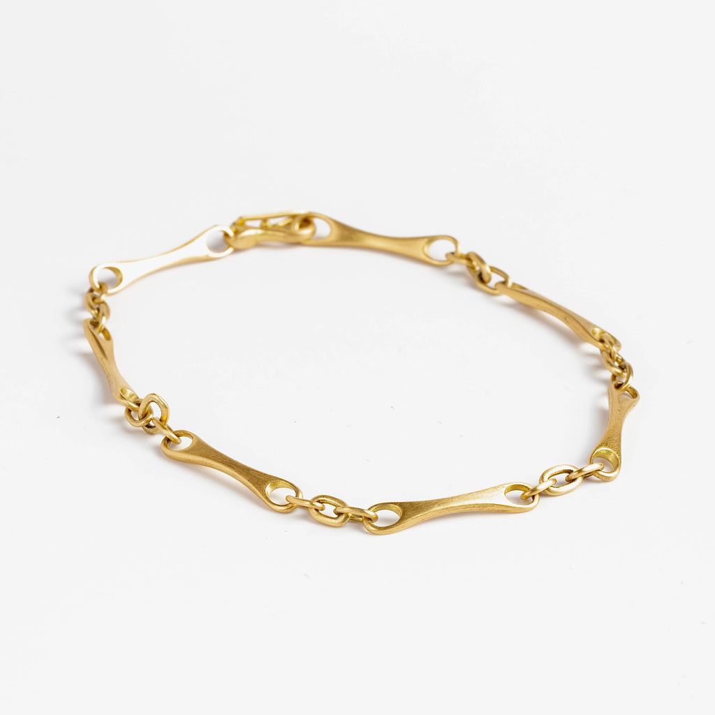 Marian Maurer City Bar Link Bracelet is a curved bone link in her signature smooth and silky 18k yellow gold with satin finish that honors New York City and cities.. This bracelet has a hook and eye closure with a safety to stay on forever.