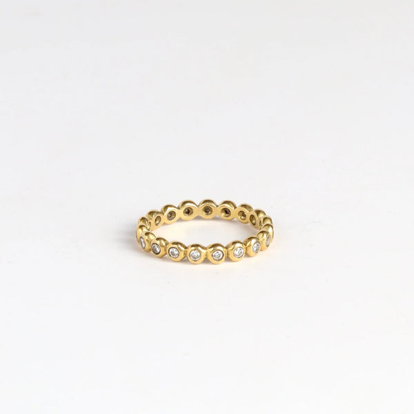 3mm thick diamond porch band by Marian Maurer on white background. This is a wedding band in bezel set round diamonds that is 3mm tall.
