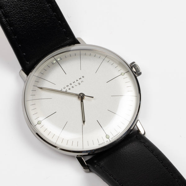 Max Bill 34mm Hand wound Watch in White Dial Without Numbers designed for Junghans in 1961 and is virtually unchanged. 34mm hand wound watch with black face and numbers with hand winding movement J805.1 (ETA 2801-2) and a sapphire crystal,  42 Hour Power Reserve in 316L stainless steel case available at OK. 27/3700.02