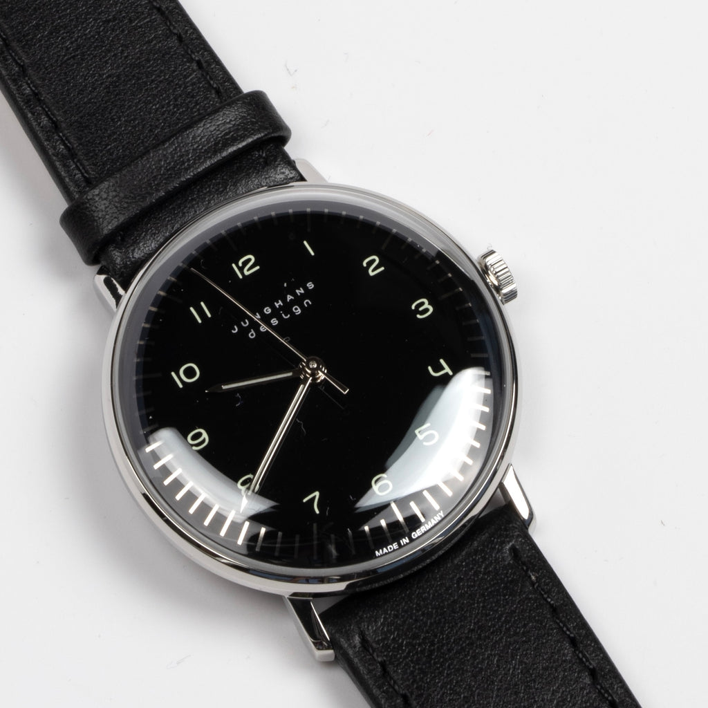 The Max Bill 34mm Hand wound wrist watch with black dial face and numbers, but no date was designed for Junghans in 1961 and is virtually unchanged. It is a classic modernist design with hand winding movement J805.1 (ETA 2801-2) and a sapphire crystal,  42 Hour Power Reserve in 316L stainless steel case available at OK