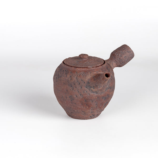 Kyusu teapot C by Muzuri ware in reddish brown is a composed ceramic teapot, utilizing mostly black stained London clay, textured and inlayed with costal wild Cornish clay. This one is inlayed with black iron oxide. Wheel thrown and assembled with interior holes to work with a variety of tea leaves by Kyriacos Mouzouris in London UK.
