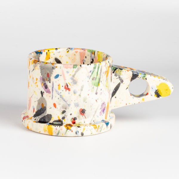 EXP Standard Splatter Mug in Black, Gray, Yellow, Purple and Red is a glazed ceramic mug with a triangular handle, made by utilizing slab construction that is hand rolled. Inspired by the techniques of Adrian Saxe and the paintings of Sam Francis, the mug was designed by LA artist, Peter Shire for Echo Park Pottery. Peter is one of the original members of the Memphis Group, founded by Ettore Sottsas in Italy. Handbuilt in Echo Park, Los Angeles.