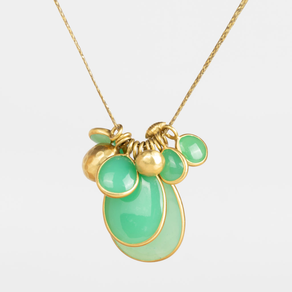 Colette Chrysoprase Cluster Necklace in Flourishing Greens is a necklace by Pippa Small Jewelry in the Flourishing Greens color way is a cluster of bezel set Chrysoprase stones in various sizes with two hammered 18k gold seed beads and one mini croissant bead on a 22" golden waxed cotton cord.