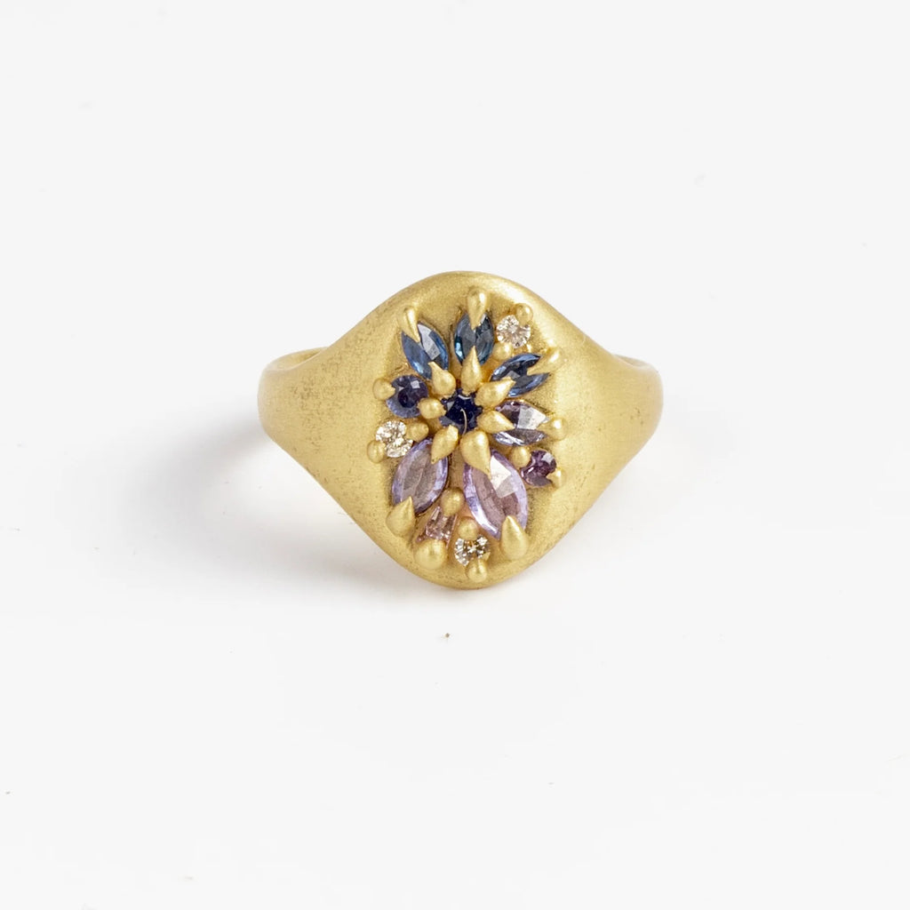 Encrusted Lotus signet by Polly Wales in purple and blue sapphires.