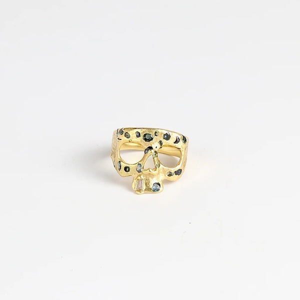 Stoned Mini Snaggle Tooth Skull ring by Polly Wales with green sapphires and a baguette diamond snaggle tooth.