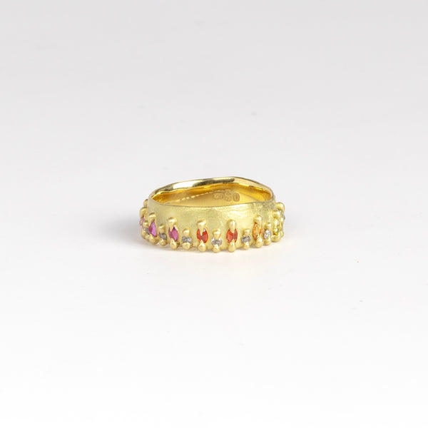 Noelle Ring by Polly Wales is a wide pinched style band in 18k recycled yellow gold, encrusted with Rainbow Marquise Sapphires in pink, orange, yellow, green and blue, and grey brilliant cut diamonds around the circumference. Recycled gold. Cast in Place. Cast not set. Handmade in Los Angeles.