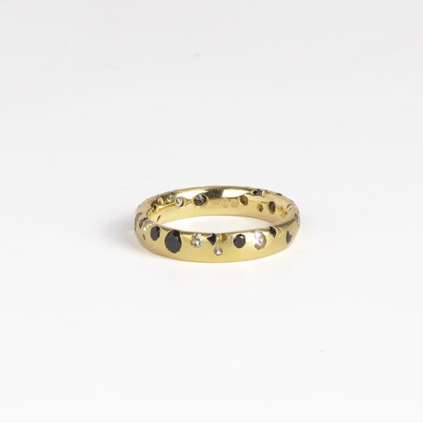 Black and White Confetti Band by Polly Wales is a narrow 18k yellow gold band with speckled black and white sapphires around the circumference for a beautiful confetti-like appearance. Recycled gold. Cast not set. Handcrafted in Los Angeles. Sie 6.5 n stock