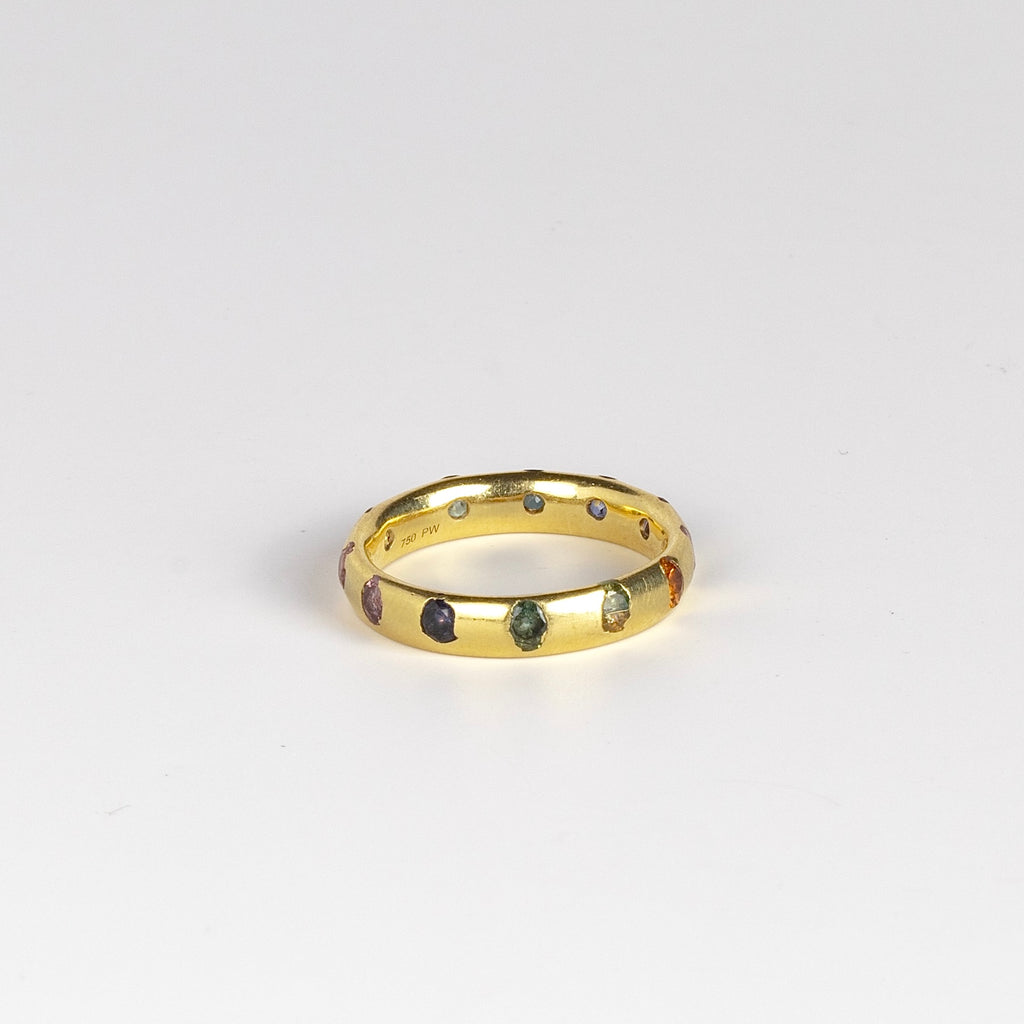Celeste Ring in Blossom Crush by Polly Wales is a wide 18k recycled yellow gold band with sparkly rainbow sapphires in orange, yellow, green, pink, blue and purple peppered around the circumference. Recycled gold. Cast in Place. Cast not set. Handmade in Los Angeles.
