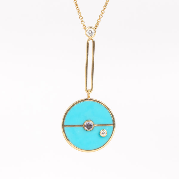 The signature Compass Pendant with Sleeping Beauty Turquoise and Tanzanite by Retrouvai is a pendant necklace with stone inlay that is accented with a center gem stone and a white diamond. The compass hangs from an elongated paperclip link accented with a second white diamond on 24" 14k yellow gold chain.