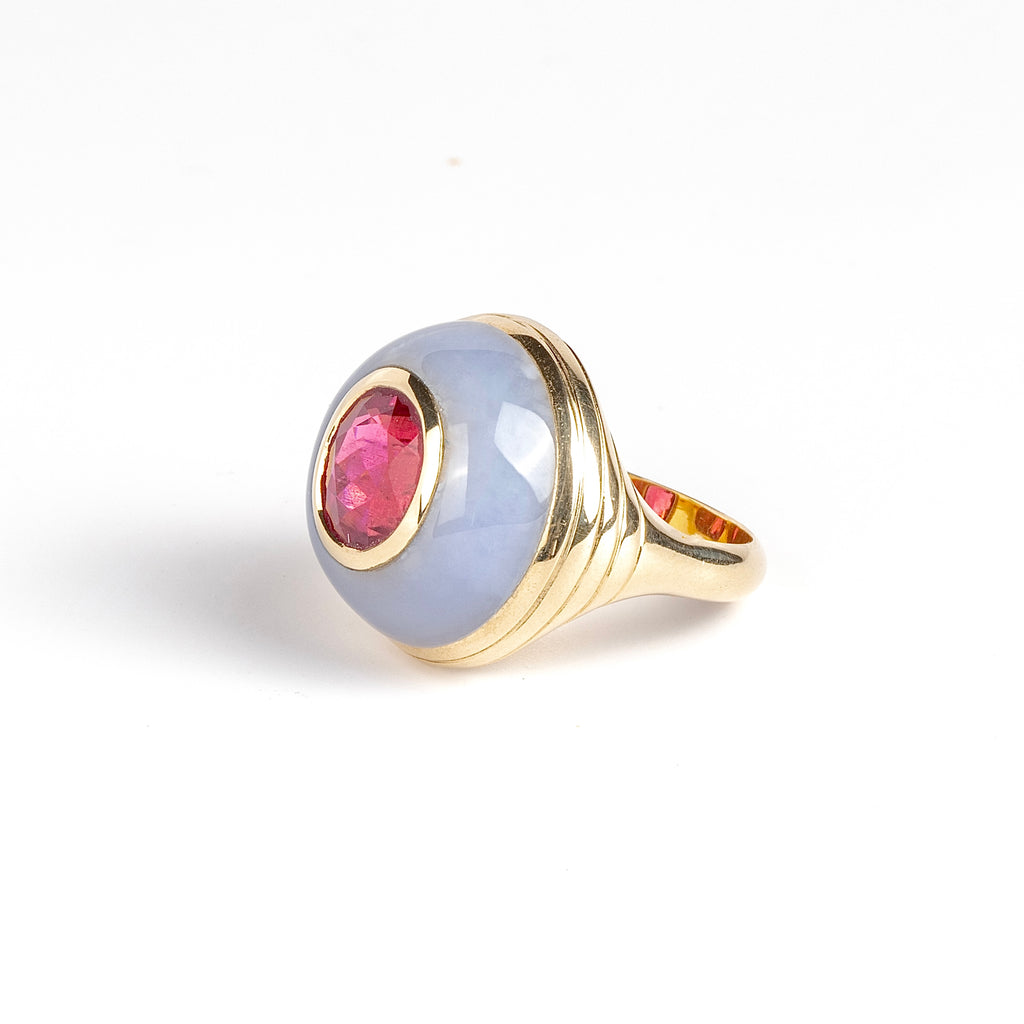 Petite Lollipop Ring Rubellite Oval in Chalcedony by Retrouvai is a one of a kind ring featuring a chunky and rounded stone face with a translucent center stone set on a&nbsp;tiered edge and tapered band. This one features hand carved chalcedony with an oval cut rubellite in the center. Handcrafted in Los Angeles.