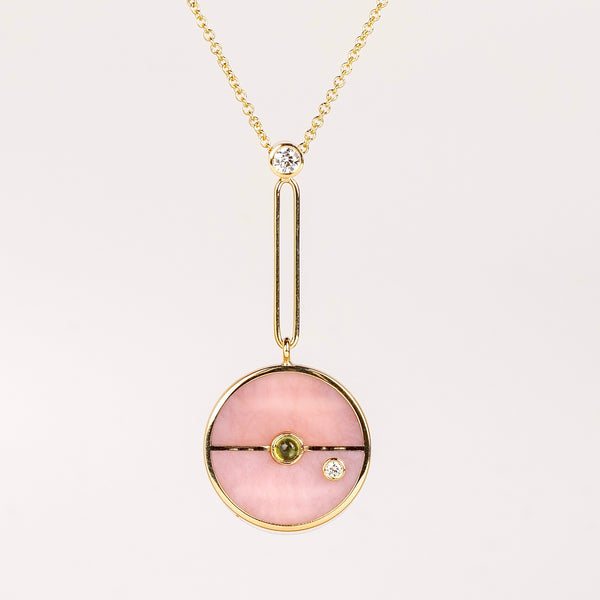 Compass Pendant in Pink Opal and Green Tourmaline by Retrouvai is a unique modern take on an heirloom pendant. Stone inlay is accented with a center gem stone and white diamond. The compass hangs from an elongated paperclip link accented with a second white diamond. Handcrafted in Los Angeles.