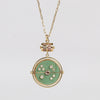  Grandfather Compass Pendant in Green Turquoise and Tanzanite by Retrouvai is a pendant necklace with stone inlay that is accented with a center gem stone in the front and back, and nine (9) round white diamonds. The compass hangs from a barrel and on a paperclip link chain in 14k yellow gold of 26" .