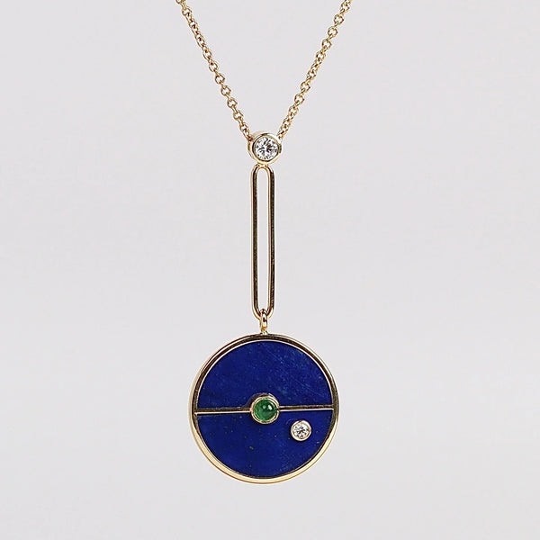 Close up of Compass Pendant Necklace in Lapis and Emerald by Retrouvai on white background. Made in LA.