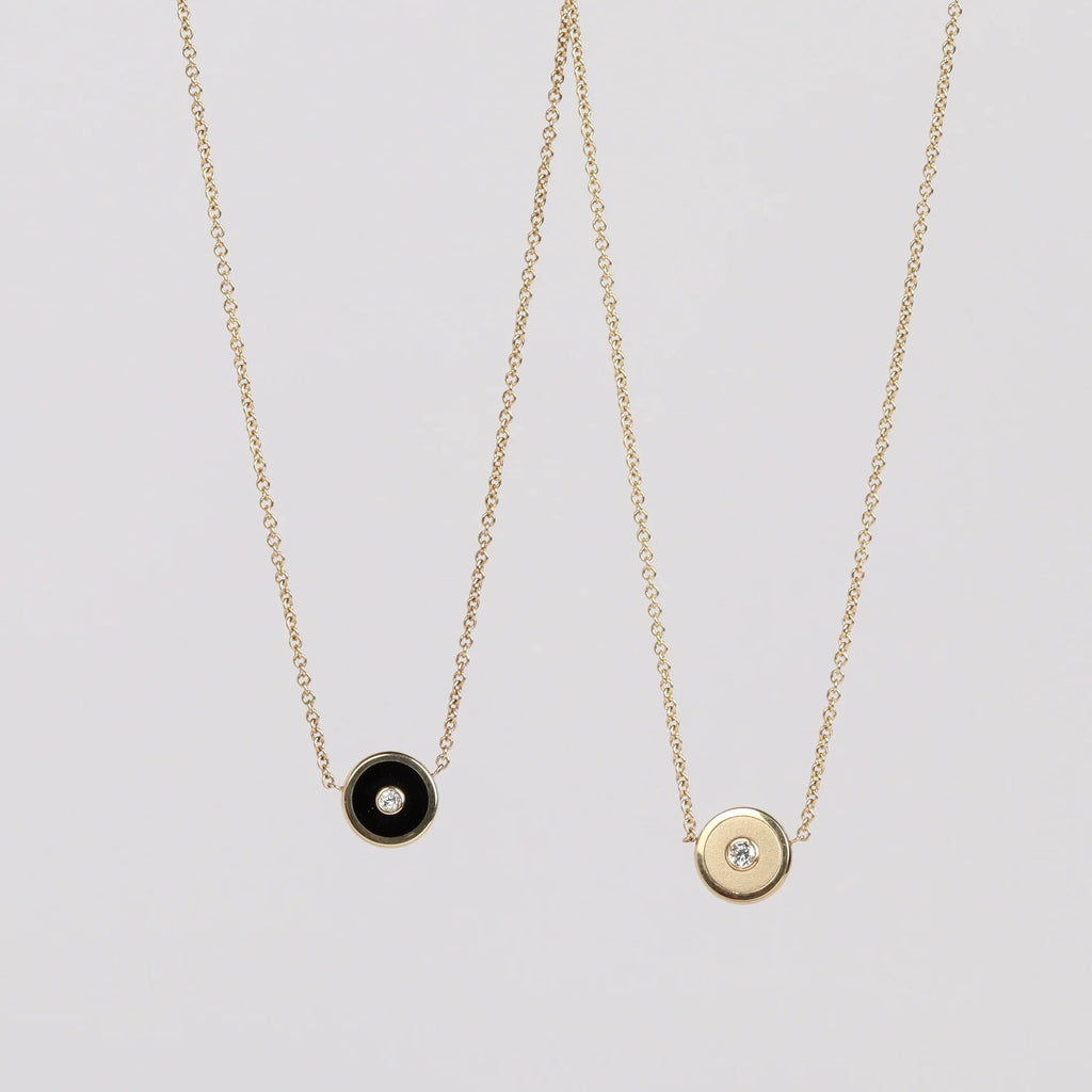 Mini Compass Pendant Necklace in Black Onyx and Brushed Gold by Retrouvai with a round white diamond center  accent on 16"  and 14k yellow gold chain on white background.
